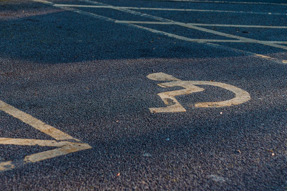Close-up view of an asphalt parking area showing a clearly visible white painted number '22' marking a parking space. The surface appears slightly textured with small pebbles embedded in the dark asphalt. Adjacent painted lines are partially visible, delineating the parking slot boundaries. The scene suggests an outdoor setting with natural lighting, likely part of a residential or commercial property accessible for home relocation services. This parking space could be used for vehicle loading or unloading during furniture transport or moving tasks. The image exemplifies typical parking lot markings relevant to planning a house removal, as provided by Man with Van Keston, ensuring efficient access for vans and moving vehicles involved in packing and moving activities.